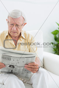 Focused elderly man reading the news