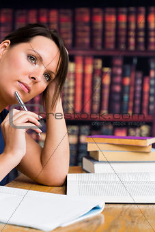 Cute woman thinking with pen and book