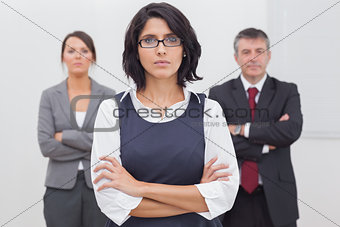 Three business people folding their arms seriously