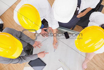 Team looking at a construction plan with hard hats