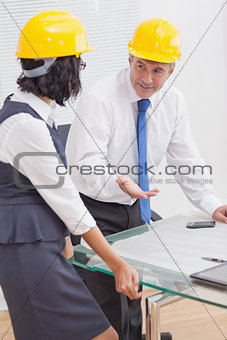 Two architects talking with yellow helmet and smile