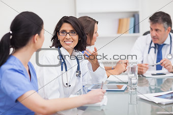 Two doctors speaking with two nurses