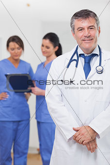Doctor smiling with nurses behind him