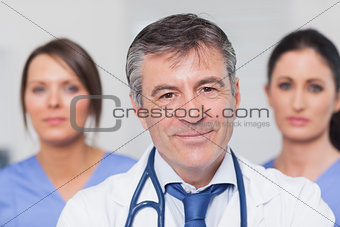 Smiling doctor with two nurses