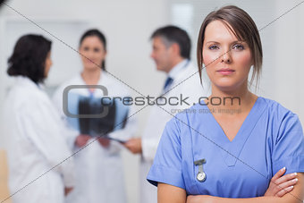 Nurse standing seriously with her team