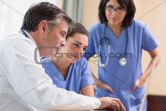 Doctor and two nurses looking at laptop