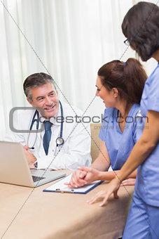 Happy nurses chatting with doctor