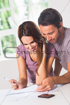 Smiling couple in front of invoices