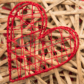 Red heart shaped ornamental box on wicker