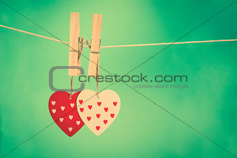 Two heart decorations hanging from pegs on a line