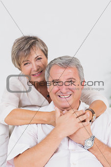 Old lovers smiling at the camera and hugging