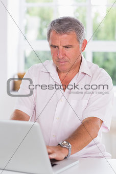 Old man using laptop seriously