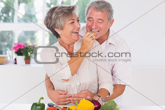 Old man tasting vegetable held by wife