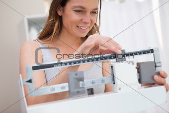 Woman adjusting medical scale