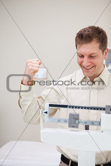 Man celebrating his victory over the scale