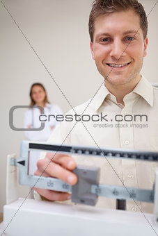 Smiling man adjusting scale