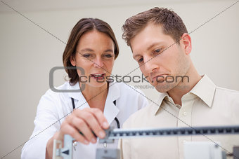 Doctor and patient measuring weight