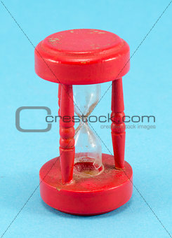 broken red sand glass clock on blue background 