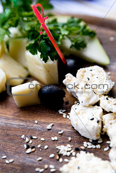 Splitting a solid tasty goat cheese with sesame seeds and herbs