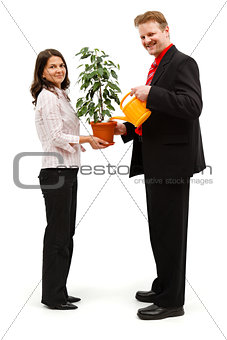 Happy couple watering plant
