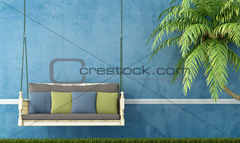 Vintage wooden swing against blue wall