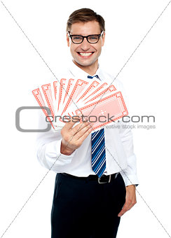 Cheerful man holding up playing cards