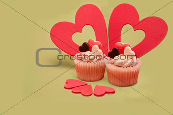 Two valentines cupcakes with five heart decorations