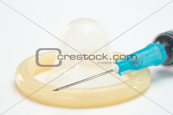 Rolled up condom and hypodermic needle