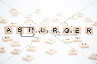 Asperger spelled out in plastic letter pieces with others scattered around