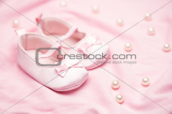 Baby girls pink booties on pink blanket