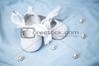White baby booties on blue blanket