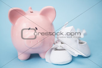 Piggy bank and white baby shoes