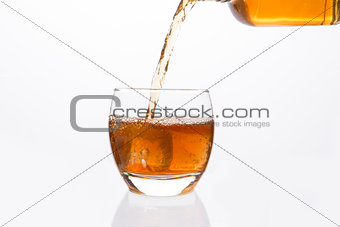 Whisky bottle pouring into glass