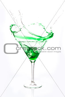 Cocktail glass with green alcohol splashing