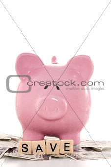 Close up of a piggy bank and save spelled out in plastic letters pieces