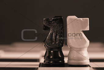Two chess knights facing away from each other