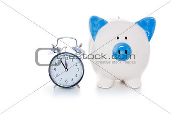 Hand painted blue and white piggy bank beside alarm clock