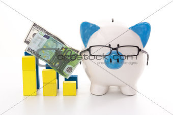 Piggy bank wearing glasses with blue and yellow graph models