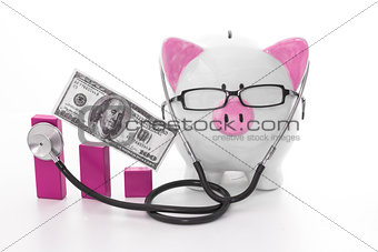 Pink and white piggy bank wearing glasses and stethoscope