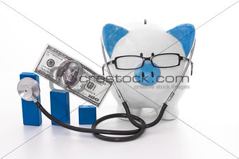 Blue and white piggy bank wearing glasses and stethoscope