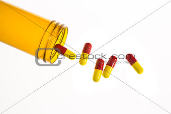 Jar of medicine spilling capsule tablets