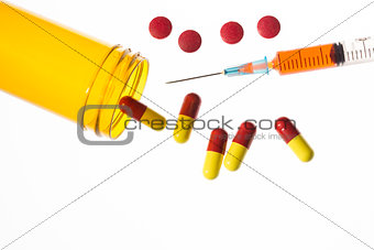 Jar of medicine spilling tablets with syringe
