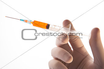 Gloved hand holding hypodermic needle