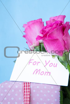 Bouquet of pink roses in vase with pink gift and mothers day card