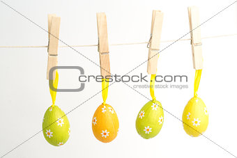 Four easter eggs hanging from a line