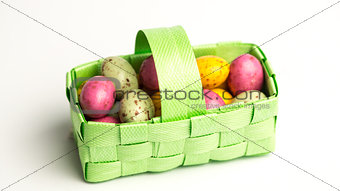 Speckled colourful easter eggs in a green basket