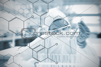 Chemist working cautiously with liquid and futuristic interface showing formula