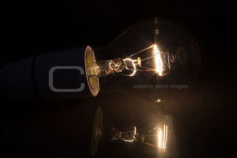 Light bulb without glass turned over on black background