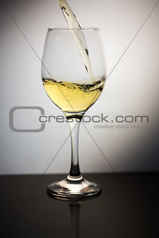 White wine being poured into clear wine glass