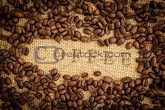 Coffee beans surrounding coffee stamp on sack